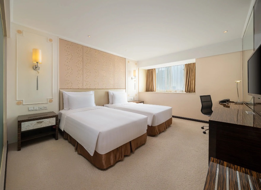 TV, beds and work desk in the Dorsett Twin Room at Dorsett Chengdu.