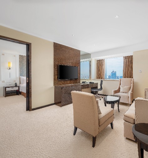 TV, sofa, work desk and bedroom in the Dorsett Chengdu Executive Suite.