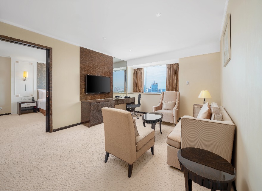 TV, sofa, work desk and bedroom in the Dorsett Chengdu Executive Suite.