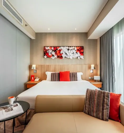 Bed and sofa in Dorsett Room at Dorsett Changi City Singapore.