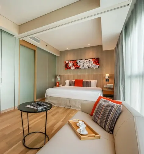 Table, bed and sofa in Splash Room at Dorsett Changi City Singapore.