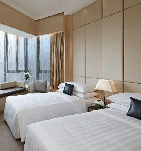 Beds, sofa and work desk in the Dorsett Kwun Tong Standard Room.