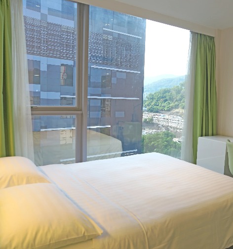 TV and bed in the Dorsett Tsuen Wan Deluxe Plus Room.