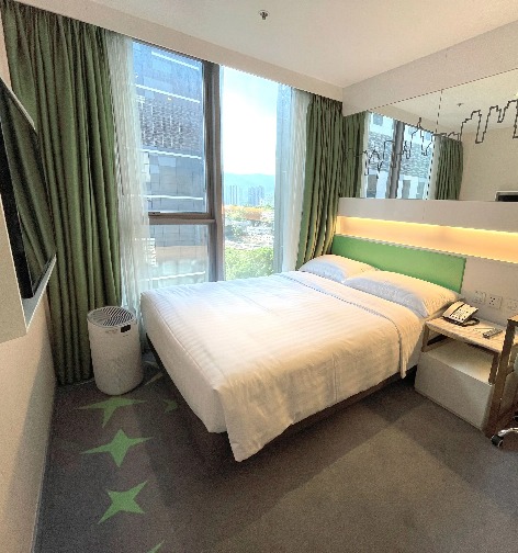 Queen bed by the window in the Dorsett Tsuen Wan Dorsett Room.