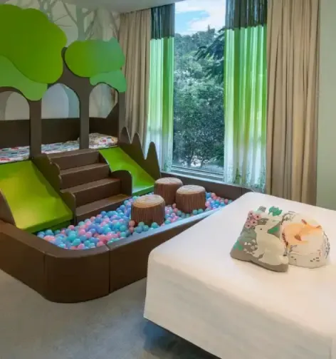 Bed by a play area in the Dorsett Tsuen Wan Forest-themed room  .