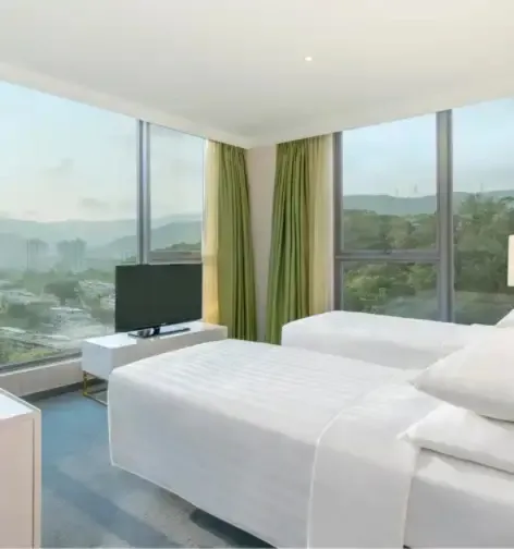 Two beds, TV and work desk in the Premier Room, Dorsett Tsuen Wan.